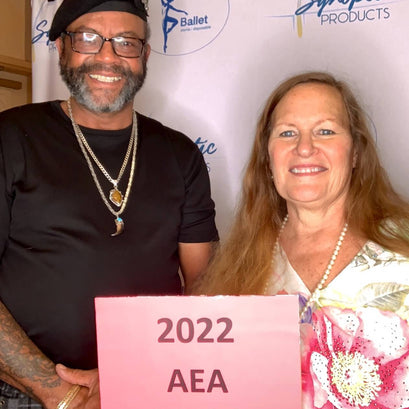 Tracy and Gezelle standing next to each other holding 2022 AEA sign